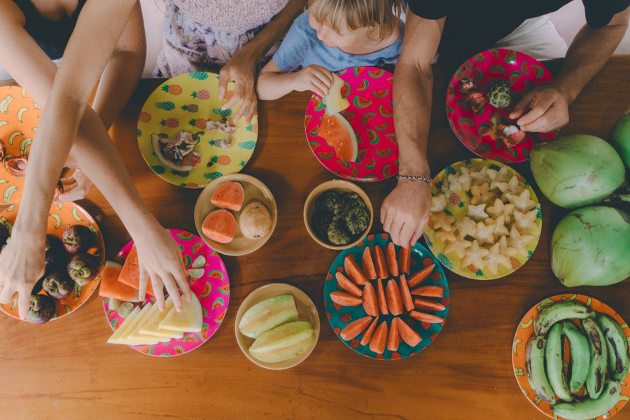 A family grabbing a range of healthy snacks such as carrot sticks and green beans