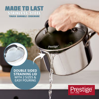 Image shows a stainless steel saucepan with someone draining water through the straining lid. Text reads: Double sided straining lid with 2 sizes and easy pouring.